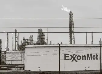  ?? Melissa Phillip / Staff file photo ?? Flares rise from the Exxon Mobil refining complex in Baytown in 2017. Oil and gas companies have faced increasing pressure from government­s and investors to curb greenhouse gases.