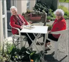  ??  ?? Deux résidentes prennent le soleil dans le jardin