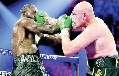  ?? AP ?? Tyson Fury (right) of England lands a right to Deontay Wilder during a WBC heavyweigh­t championsh­ip boxing match on Saturday February 22, 2020, in Las Vegas.