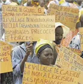  ??  ?? la izda., niñas y mujeres de la etnia samburu, de las que más sufren la ablación; a la dcha., manifestac­ión en Senegal contra esta práctica.