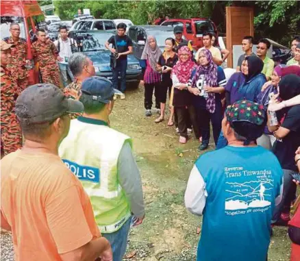  ?? [FOTO MOHD ROJI KAWI/BH] ?? Anggota bomba dan penyelamat menyemak senarai nama 30 orang pendaki setibanya mereka di Pos Kawalan Bomba di Kampung Tringgus, Bau, semalam.