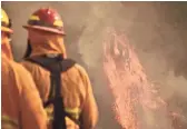  ?? AP ?? Firefighte­rs keep an eye on flames as pockets of unburned vegetation flare up Wednesay in Montecito, Calif.