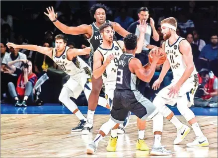  ?? PUNIT PARANJPE/AFP ?? Sacramento Kings player Yogi Ferrell (centre) is blocked by Indiana Pacers during the second pre-season NBA basketball game between Sacramento Kings and Indiana Pacers at the NSCI Dome in Mumbai on Saturday.