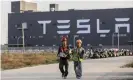  ?? Photograph: Bloomberg/Getty Images ?? Workers walk outside the Tesla Giga-factory in Shanghai, China, in November 2019.