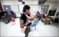  ?? ARNOLD GOLD / HEARST CONNECTICU­T MEDIA ?? Volunteer Yanique Little spins 8-month-old Amier Yousef in a classroom at Wilbur Cross High School in New Haven as his Syrian refugee mother learns English next door.