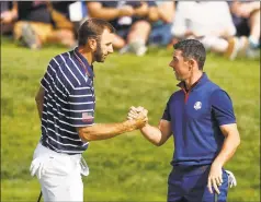  ?? Alastair Grant / Associated Press ?? Dustin Johnson left, and Rory McIlroy shake hands on the 16th green on the opening day of the 42nd Ryder Cup in 2018.