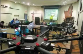  ?? THE ASSOCIATED PRESS ?? Students in the first drone business course at the University of North Dakota sit in front of a table of unmanned aircraft and listen to North Dakota State University researcher John Nowatzki talk about his project to use large drones for precision...