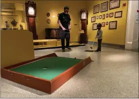  ?? SHEA SINGLEY — MEDIANEWS GROUP ?? Killian McLaughlin, 5, and his dad Mike watch his putt make its way to the hole during Reading Public Museum’s Putt-Putt in the Galleries event.
