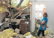  ?? KAYLA O'BRIEN/STAFF ?? Phyllis Walters and her dog, Snoop, look at their damaged home on Cayman Way in Orlando. Hurricane Irma brought hours of rain and wind.