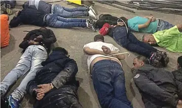  ??  ?? Foiled: Gang members lie face down after being arrested near the tunnel entrance