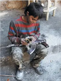  ??  ?? A 13-year-old fighter from the Free Syrian Army in Aleppo, Syria.
