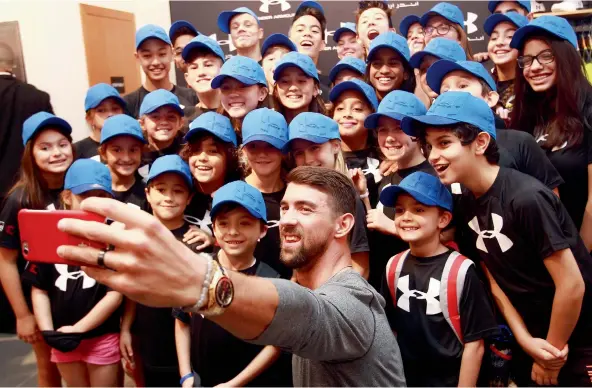  ??  ?? Michael Phelps with young UAE swimmers at The Dubai Mall yesterday. Maybe there’s a future gold medal winner in the crowd?