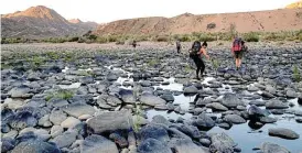  ?? ?? Starts and stops: Above: Sunrise start on the Fish River. Below: One of life’s greatest pleasures might be crouching by a clean-flowing river and letting water trickle into a waterbottl­e.