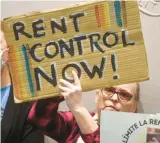  ?? ?? Greta Blau, from the Hamden Tenants Union, holds a sign supporting a bill to cap annual rent increases.