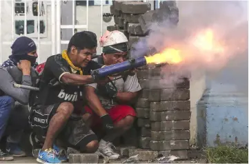  ??  ?? An anti-government demonstrat­or fires a home-made mortar during clashes with riot police at a barricade in the town of Masaya. — AFP photo