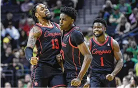  ?? ANDY NELSON / ASSOCIATED PRESS ?? Houston guard Terrance Arceneaux (center) celebrates his 3-pointer against Oregon with forward J’wan Roberts (13) and guard Jamal Shead (1) on Nov. 20. The Cougars received 45 of 63 first-place votes from a national media panel and are atop the AP’S Top 25 rankings for the first time in nearly 40 years.