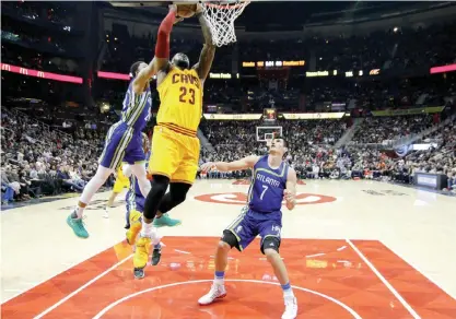  ??  ?? ATLANTA: Cleveland Cavaliers forward LeBron James (23) shoots past Atlanta Hawks forward Kent Bazemore (24) and forward Ersan Ilyasova (7) in the second half of an NBA basketball game, Friday, in Atlanta. — AP