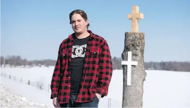  ?? JUSTIN TANG / THE CANADIAN PRESS ?? Blake Murray stands near the tree into which he carved a cross with his chainsaw. A local family says it is grateful to him for saving the roadside memorial devoted to a loved one that was killed in a 2001 car crash.