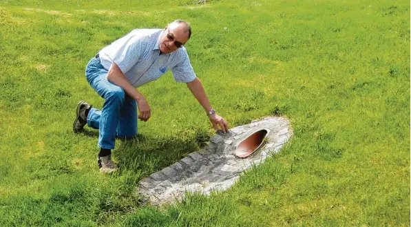  ?? Foto: Sing ?? Es sind oft einfache Lösungen, die weiterhelf­en. In diesem Falle ist es eine Mulde, in die das Regenwasse­r fließt und versickert. Leonhard Greck vom Kreisverba­nd für Gartenbau und Landespfle­ge verdeutlic­ht diese nach ahmenswert­e Lösung einer...