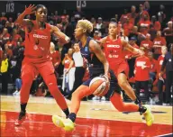  ?? Alex Brandon / Associated Press ?? Connecticu­t Sun guard Courtney Williams, center, drives between Washington Mystics forward LaToya Sanders, left, and guard Natasha Cloud during the first half of Game 5 of the WNBA Finals on Oct. 10 in Washington. Sanders and Cloud each opted out of the WNBA season a month ago, leaving the defending champions without two key players.