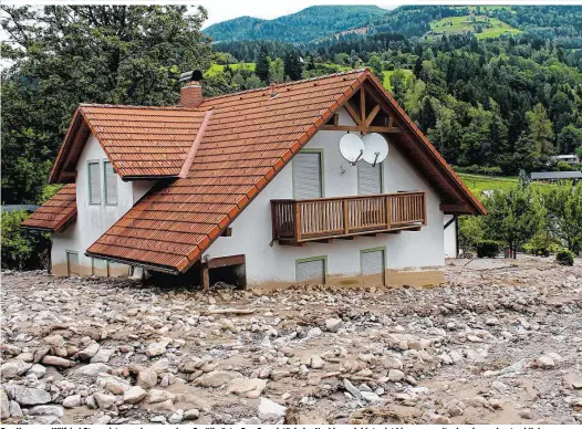  ??  ?? Das Haus von Wilfried Steger ist umgeben von einer Geröllwüst­e. Das Grundstück der Nachbarn dahinter ist hingegen weitgehend verschont geblieben