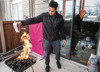  ?? Brett Coomer / Staff photograph­er ?? Kevin Morazan lights his charcoal grill to cook food after losing power in the Greenspoin­t area due to blackouts during the freeze and ensuing electricit­y crisis in February.