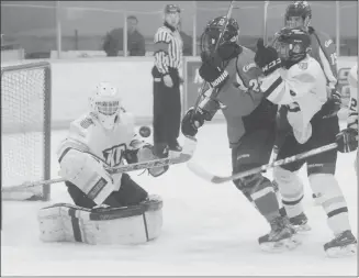  ?? Herald photo by Dale Woodard ?? Lethbridge midget AAA Hurricanes forward Zack Stringer and Edmonton Knights of Columbus Pats goaltender Braedan Stephen keep an eye on the puck as it soars through the air during the second period of Game 5 of the Alberta Midget Hockey League...