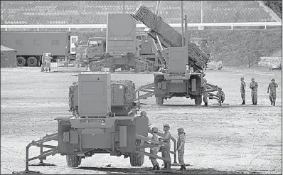  ?? AP/RYOSUKE OZAWA ?? Members of the Japanese military work on a Patriot missile-defense system Saturday in Konan in Kochi prefecture, one of four batteries just deployed in northern Japan.