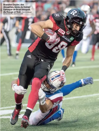  ?? PHOTO MARC DESROSIERS, AGENCE QMI ?? Branden Dozier, des Alouettes, tente de freiner l’attaque de Brad Sinopoli, du Rouge et Noir.