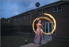  ?? OLI SCARFF / AGENCE FRANCE-PRESSE ?? Katia McGurk, an aerial and fire performer, practices her fire skills in the garden of her home in Daventry, central England, on Saturday, amid the COVID-19 pandemic.