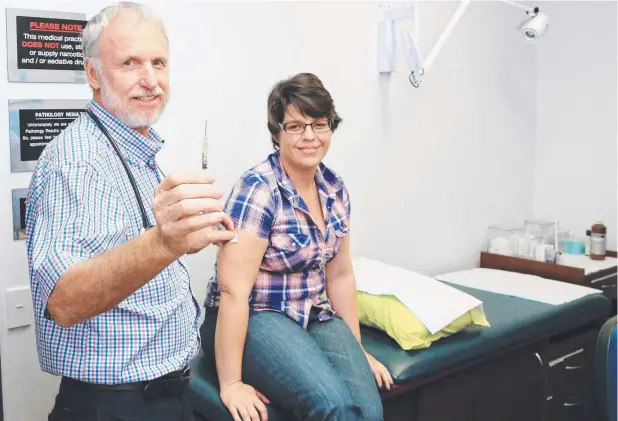  ?? Picture: JUSTIN BRIERTY ?? PREVENTION: Dr Gavin Le Sueur prepares an injection for Celiamaree Bonso to guard against whooping cough.