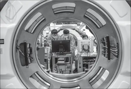  ?? PROVIDED TO CHINA DAILY ?? Employees work on a CT scanner production line of Neosoft Corp in Shenyang, Liaoning province.