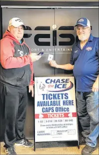  ?? SUBMITTED PHOTO ?? Scott Bridges, (left) manager of Slemon Park Plex, shows how Chase The Ice tickets can be purchased online, including from a phone, while Cecil Gallant, vice-president of the Capitals Booster Club, holds the elusive Ace of Spades which still remains in...