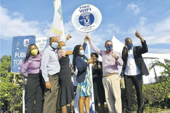  ?? (Photo: JIS) ?? Minister of Science, Energy and Technology Daryl Vaz (second right) gives the thumbs up at the launch of free, public Wi-fi in the town of Ocho Rios, St Ann, on December 4. He is joined by (from left) director, enterprise, government and IT solutions at Cable and Wireless Business, Carol Robertson; councillor for the Ocho Rios Division, Michael Belnavis; Minister of Education, Youth and Informatio­n Fayval Williams; state minister in the Ministry of Finance and the Public Service and Member of Parliament for North Eastern St Ann Marsha Smith; Charmaine Dean, representa­tive of custos rotulorum of St Ann, Norma Walters; and chief executive officer, Universal Service Fund, Daniel Dawes.