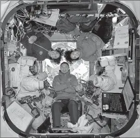  ?? AP ?? This photo provided by NASA shows astronauts Andrew Morgan (center), Christina Koch and Jessica Meir at the Internatio­nal Space Station on Friday.