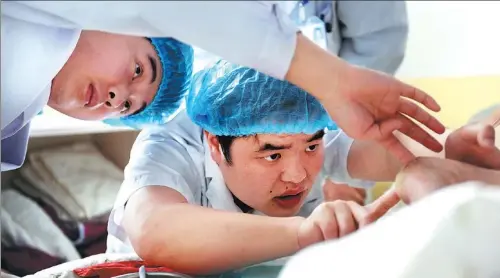  ?? GAO BO / FOR CHINA DAILY ?? Wu Xufeng (right) treats a patient in the intensive care unit at the Hefei Binhu Hospital, Anhui province.