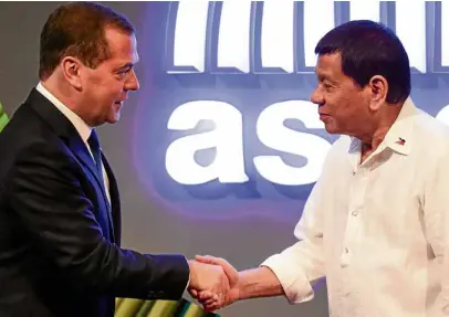  ?? —AFP ?? SUMMITWELC­OME President Duterte welcomes Russian Prime Minister Dmitry Medvedev before Monday’s opening ceremony of the Asean Summit.