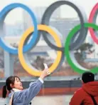  ?? AP ?? A woman poses for a selfie in front of Olympic rings at Odaiba waterfront in Tokyo, on Jan. 26.