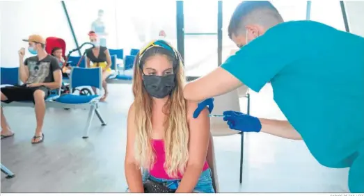  ?? CARLOS DE SAÀ / EFE ?? Una joven recibiendo ayer su dosis en el centro de vacunación habilitado en el muelle de Gran Tarajal, en Fuertevent­ura.