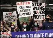  ?? ALBERTO PEZZALI — THE ASSOCIATED PRESS ?? People hold up placards as they demonstrat­e in front of the Standard and Chartered Bank during a climate protest in London, England, on Friday.