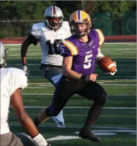  ?? RANDY MEYERS — THE MORNING JOURNAL ?? Avon quarterbac­k Ryan Maloy scrambles left against the Akron Buchtel defense for a gain during the first quarter on Aug. 23.