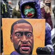  ?? (AP/Jim Mone) ?? A protester carries a portrait of George Floyd on Monday during a march around the Hennepin County Government Center in Minneapoli­s, where jury selection is ongoing in the case of former police officer Derek Chauvin.