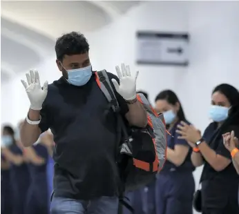  ?? Chris Whiteoak / The National ?? Staff at the temporary hospital at Dubai Parks and Resorts line up to say farewell to their last coronaviru­s patients yesterday