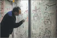  ?? LI HE / XINHUA ?? From Top: A relic worker restores wall paintings in Cave 55 of the Mogao Grottoes in Dunhuang, Gansu province, in August.