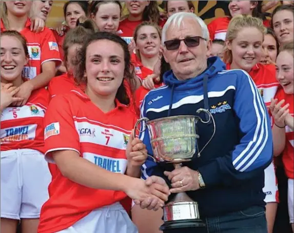  ??  ?? Dave Daly of the Munster Council presents the cup to winning captain Ciara Hughes