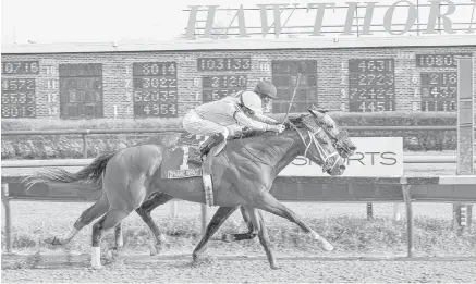  ?? | FOUR FOOTED FOTOS ?? With Miguel Mena in the irons, Dynamic Impact (1) noses out Midnight Hawk to win the Illinois Derby. The runner-up is co-owned by Joel Quennevill­e.