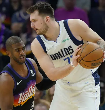  ?? Matt York, The Associated Press ?? Suns guard Chris Paul, left, defends against Mavericks guard Luka Doncic during the first half Sunday in Phoenix.