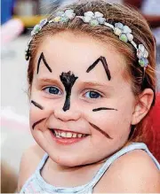  ??  ?? Cataleya Barby, 5, of Moore, smiles after having her face painted Tuesday night in the Target parking lot.