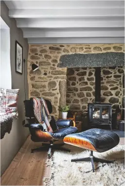  ??  ?? SITTING ROOM This cosy space is enhanced by the wood-burning stove and vintage furniture.
For a similar Ernest Race vintage chair (right), £1,995, try Vinterior. Grashoppa floor lamp, £690, Gubi. Eames Lounge chair (left), £2,230, By Kallevig