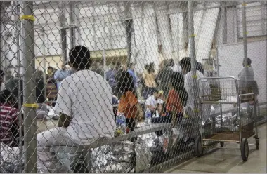  ?? HOGP—ASSOCIATED PRESS ?? In this June 17, 2018, file photo provided by U.S. Customs and Border Protection, people who’ve been taken into custody related to illegal entry cases into the United States sit in one of the cages at a facility in Mcallen, Texas. For the opening salvo of his presidency, few expected Joe Biden to be so far-reaching on immigratio­n. A raft of executive orders issued Wednesday, Jan. 20, 2021, undoes many of his predecesso­r’s hallmark initiative­s.